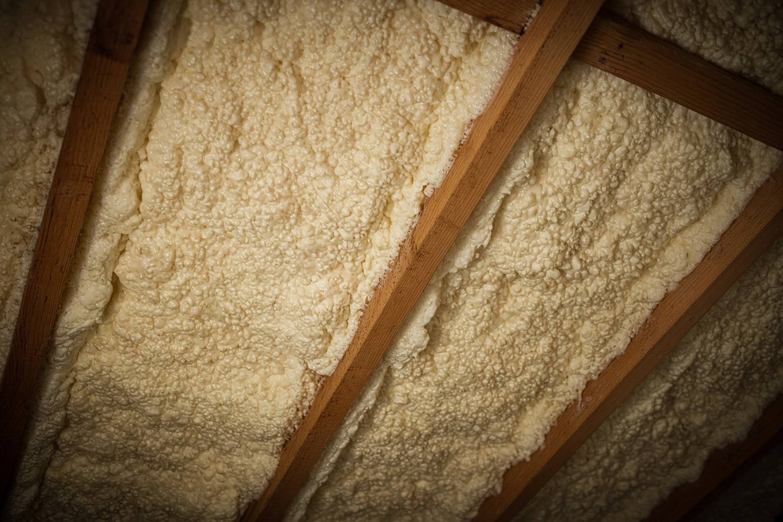 Roof deck between rafters coated in spray foam
